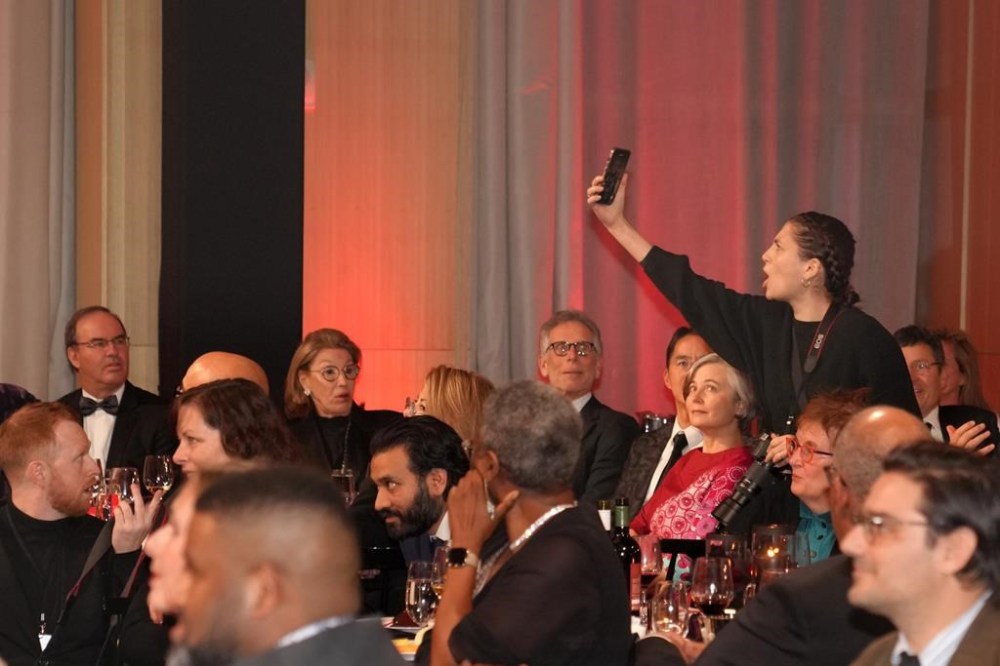 A protester films herself as she interrupts the Scotiabank Giller Prize in Toronto, on Monday, Nov. 13, 2023. The Scotiabank Giller Prize won't drop its lead sponsor, despite mounting pressure from some high-profile members of the literary community. THE CANADIAN PRESS/Chris Young