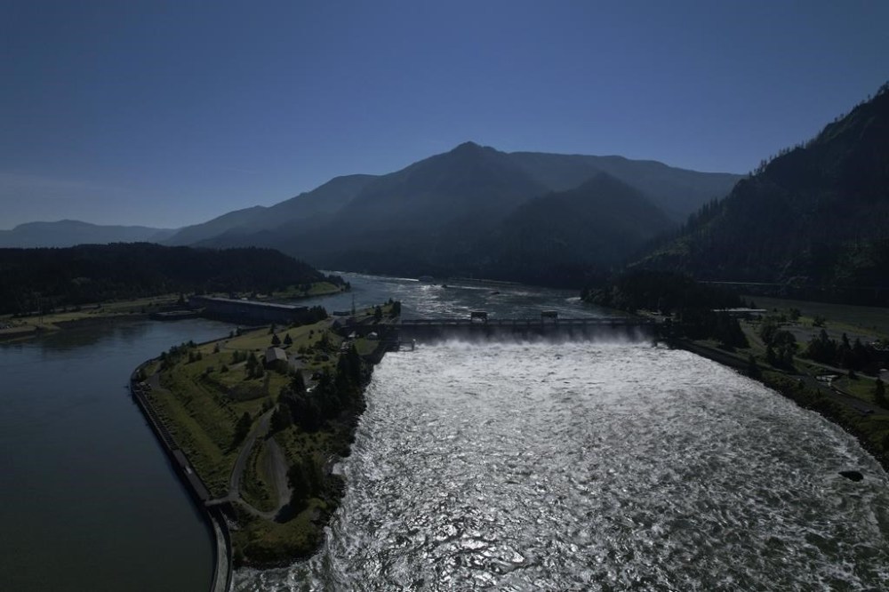 FILE - Water spills over the Bonneville Dam on the Columbia River, which runs along the Washington and Oregon state line, June 21, 2022. The U.S. and Canada said Thursday, July 11, 2024, that they have agreed to update a six-decade-old treaty that governs the use of one of North America’s largest rivers, the Columbia, with implications for electricity prices, irrigation, flood control and imperiled salmon runs. (AP Photo/Jessie Wardarski, File)