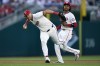 Washington Nationals third baseman Nick Senzel, left, throws an infield ground ball to first base ahead of shortstop CJ Abrams, right, during the fifth inning of a baseball game against the New York Mets at Nationals Park, Monday, July 1, 2024, in Washington. (AP Photo/Mark Schiefelbein)