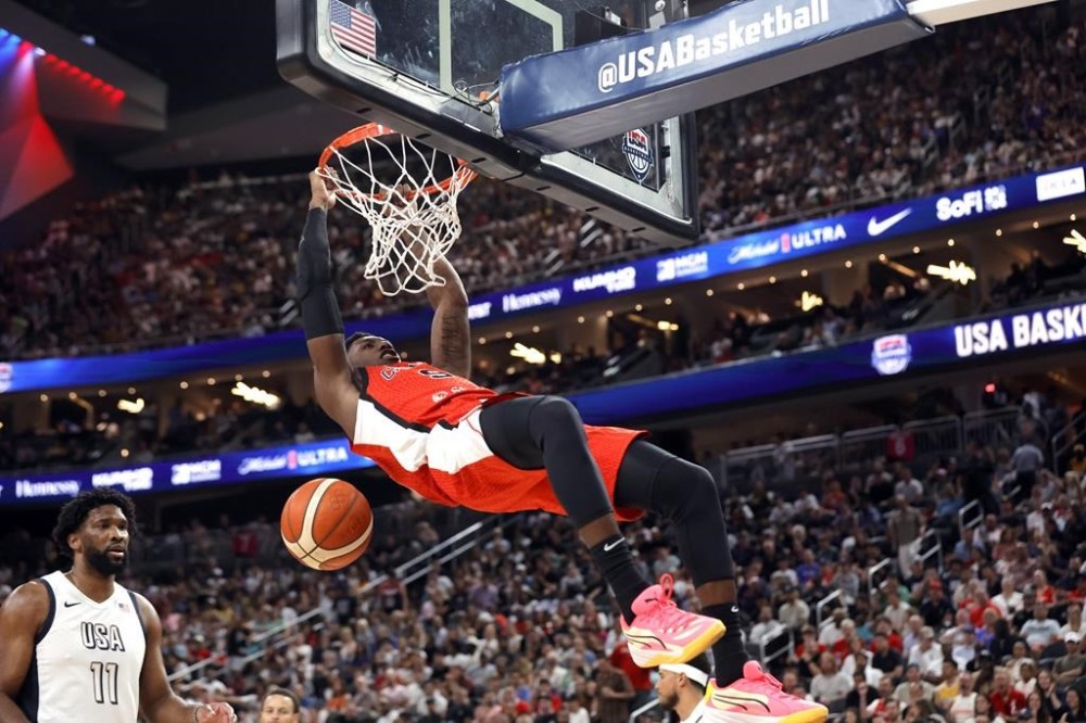 Canada guard RJ Barrett (9) dunks the ball as United States centre Joel Embiid (11) looks on during the second half of an exhibition basketball game on Wednesday, July 10, 2024, in Las Vegas. There’s an immense amount of pride in the heights Canadian basketball has reached entering the Olympics, both on the men’s and women’s sides. THE CANADIAN PRESS/AP/Steve Marcus