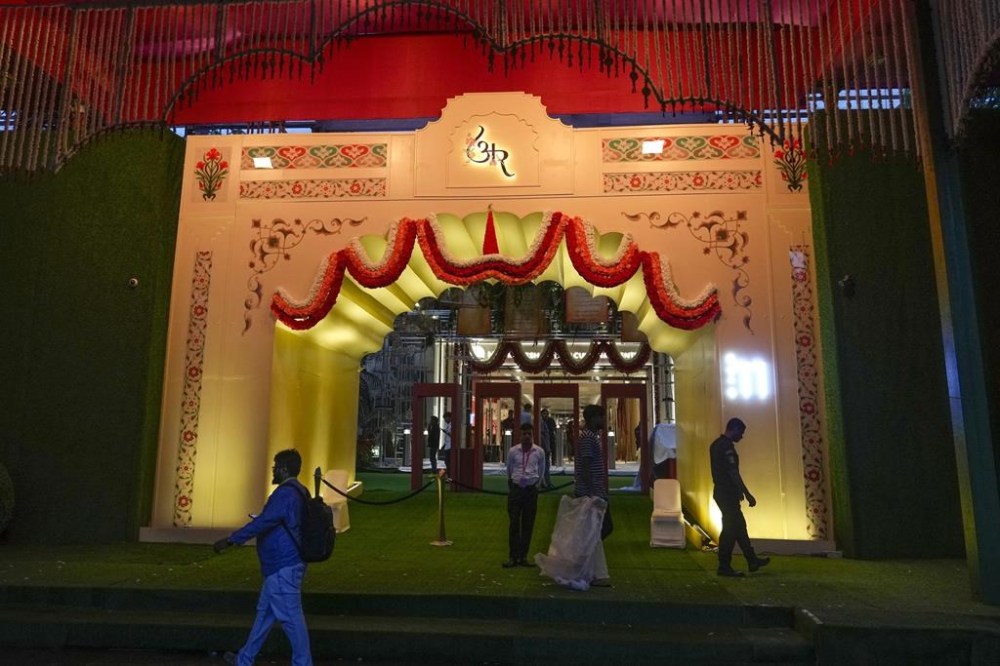 FILE - People walk past the venue decorated with lights ahead of billionaire Mukesh Ambani's son Anant Ambani's wedding to Radhika Merchant at Jio World Convention Centre in Mumbai, India, Thursday, July 11, 2024. The youngest son of Mukesh Ambani, Asia’s richest man, has married his longtime girlfriend in what many have dubbed the wedding of the year. The wedding early Saturday was being attended by global celebrities, business tycoons and politicians, highlighting the billionaire’s staggering wealth and rising clout, and came after months of festivities.(AP Photo/Rafiq Maqbool, File)
