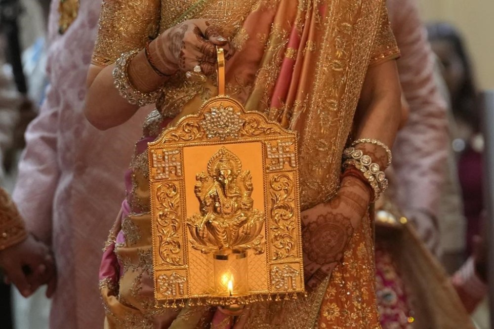 Nita Ambani, wife of Asia's richest man, Mukesh Ambani, arrives holding a lamp with an image of elephant-headed Hindu god Ganesha, for the wedding of their youngest son Anant Ambani in Mumbai, India, Friday, July 12, 2024. (AP Photo/Rafiq Maqbool)