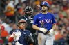 Texas Rangers' Josh Smith, right, walks to first base after being hit by a pitch during the sixth inning of a baseball game against the Texas Rangers, Saturday, July 13, 2024, in Houston. (AP Photo/Eric Christian Smith)