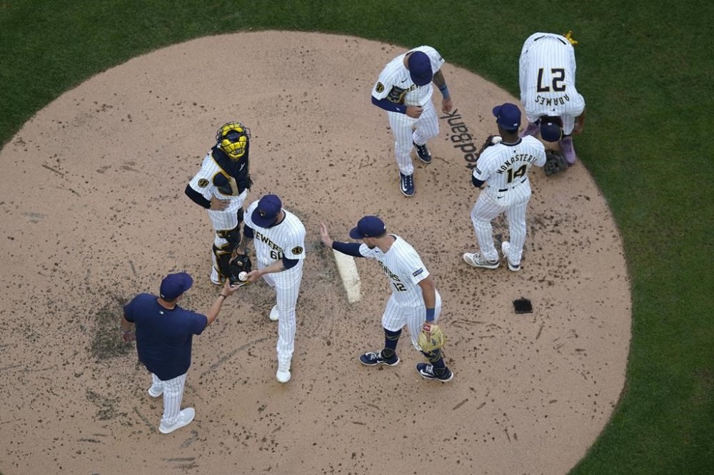 Milwaukee Brewers' Dallas Keuchel (60) hands the ball to manager Pat Murphy, left, as he is taken out during the fourth inning of a baseball game against the Washington Nationals, Saturday, July 13, 2024, in Milwaukee. (AP Photo/Aaron Gash)