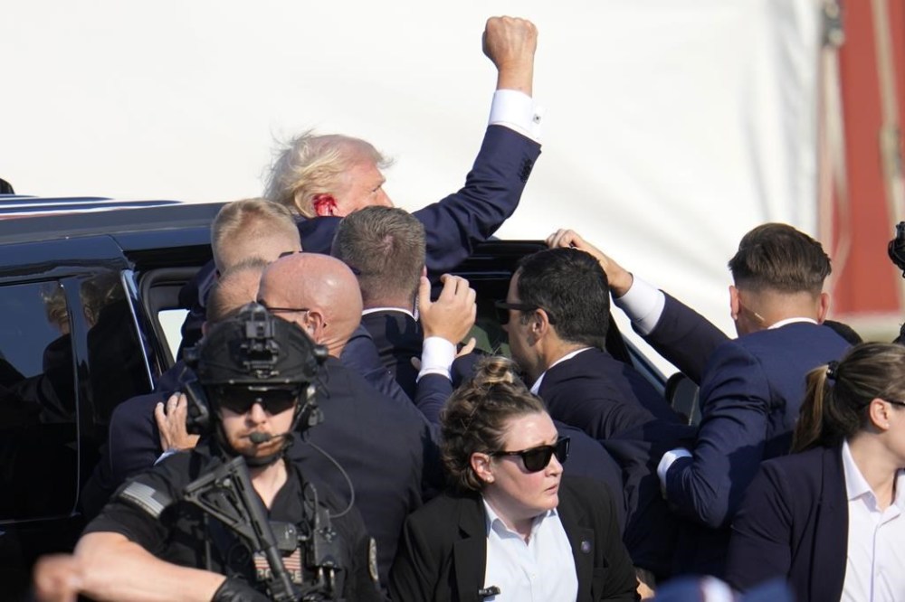 Republican presidential candidate former President Donald Trump is helped off the stage at a campaign event in Butler, Pa., on Saturday, July 13, 2024. (AP Photo/Gene J. Puskar)