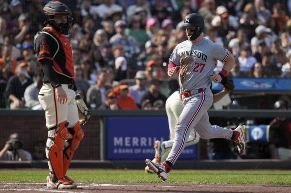 Minnesota Twins' Ryan Jeffers, right, scores next to San Francisco Giants catcher Patrick Bailey, left, on Matt Wallner's double during the fourth inning of a baseball game Saturday, July 13, 2024, in San Francisco. (AP Photo/Godofredo A. Vásquez)