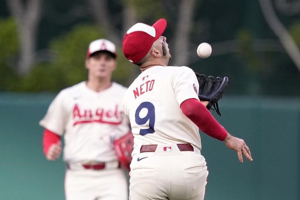 Los Angeles Angels shortstop Zach Neto, right, can't handle a ball hit by Seattle Mariners' Mitch Garver as center fielder Mickey Moniak watches during the first inning of a baseball game Saturday, July 13, 2024, in Anaheim, Calif. Garver was safe at first on the play. (AP Photo/Mark J. Terrill)