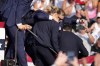Republican presidential candidate former President Donald Trump is helped off the stage by U.S. Secret Service agents at a campaign event in Butler, Pa., on Saturday, July 13, 2024. (AP Photo/Gene J. Puskar)