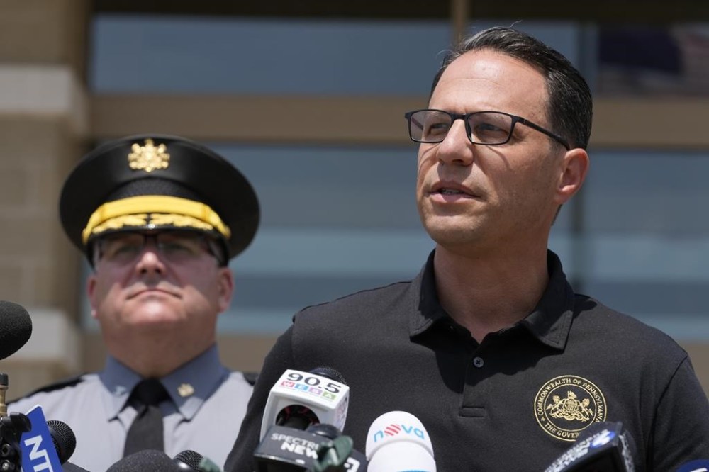 Josh Shapiro, right, governor of Pennsylvania, speaks during a news conference, in Butler, Pa., Sunday, July 14, 2024, concerning the apparent assassination attempt of former President Donald Trump. (AP Photo/Sue Ogrocki)