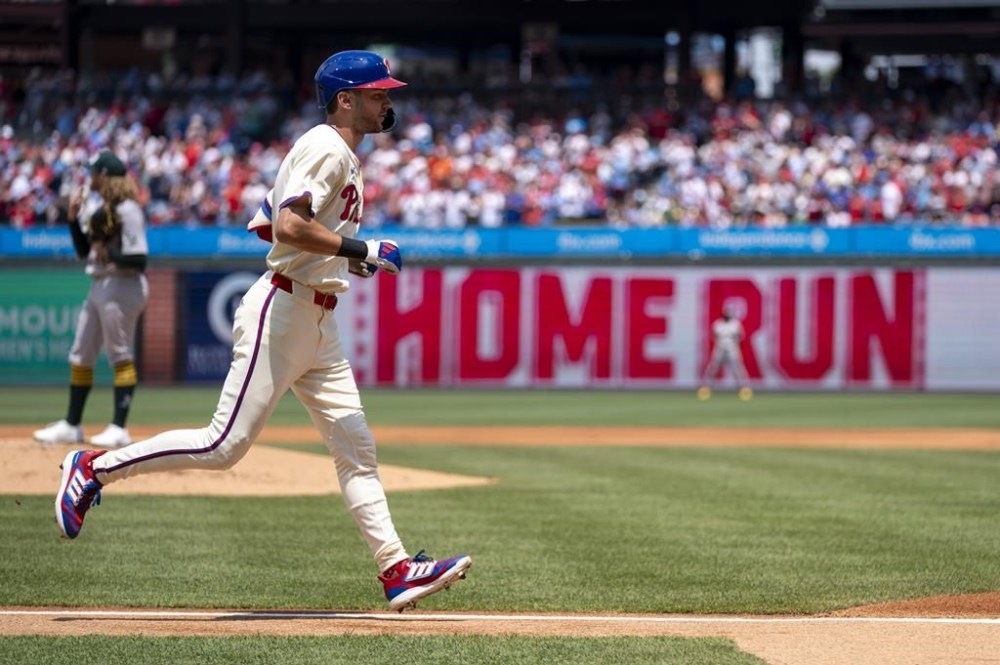Philadelphia Phillies' Trea Turner, right, rounds the bases after hitting a solo home run against Oakland Athletics starting pitcher Joey Estes, left, during the first inning of a baseball game, Sunday, July 14, 2024, in Philadelphia. (AP Photo/Chris Szagola)