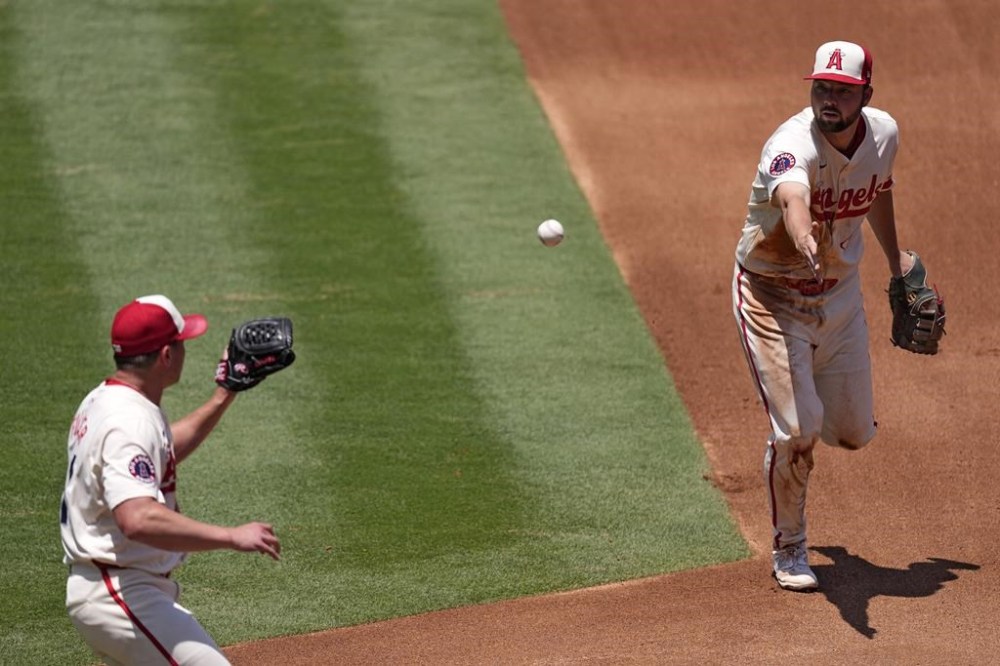 Los Angeles Angels first baseman Nolan Schanuel, right, tosses the ball to starting pitcher Carson Fulmer to force out Seattle Mariners' Victor Robles at first during the third inning of a baseball game Sunday, July 14, 2024, in Anaheim, Calif. (AP Photo/Mark J. Terrill)