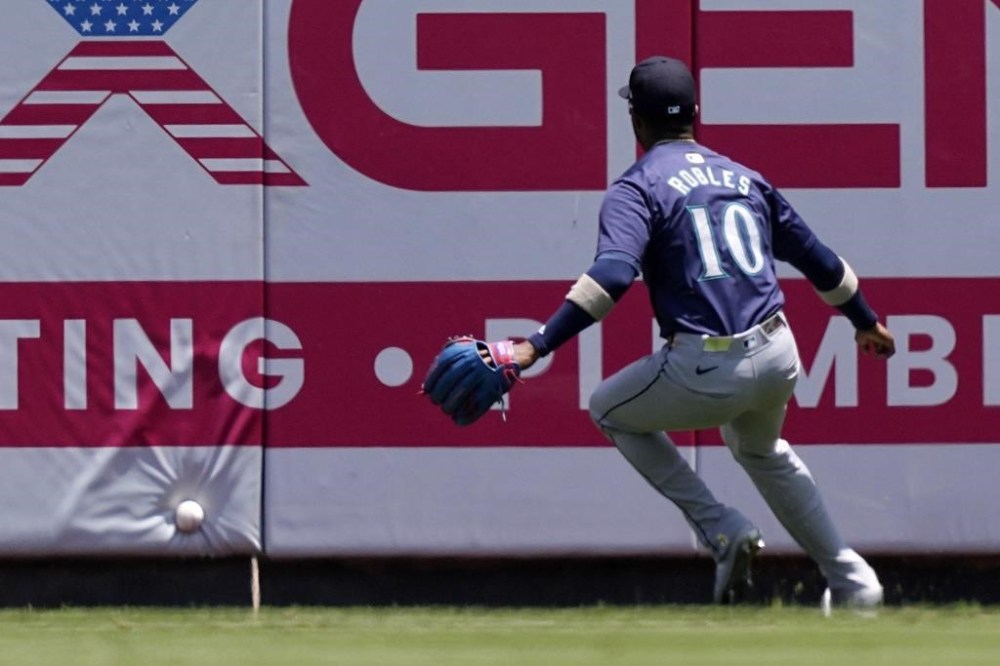 Seattle Mariners right fielder Victor Robles fields a ball hit by Los Angeles Angels' Nolan Schanuel for a double during the first inning of a baseball game Sunday, July 14, 2024, in Anaheim, Calif. (AP Photo/Mark J. Terrill)