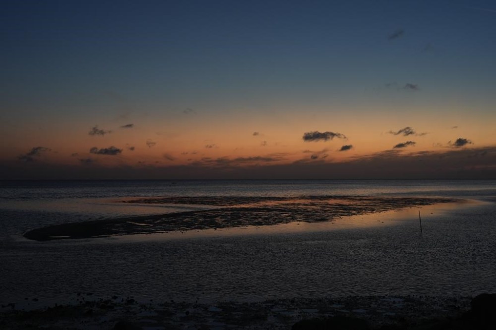 A sunset sky reflects off of water surrounding a sandbar just off the coast of Horseshoe Beach, Fla., Wednesday, May 8, 2024. Residents of the sleepy fishing village say big storms not only reshape the town, but shift the underwater landscape they navigate with their fishing boats. (AP Photo/Rebecca Blackwell)