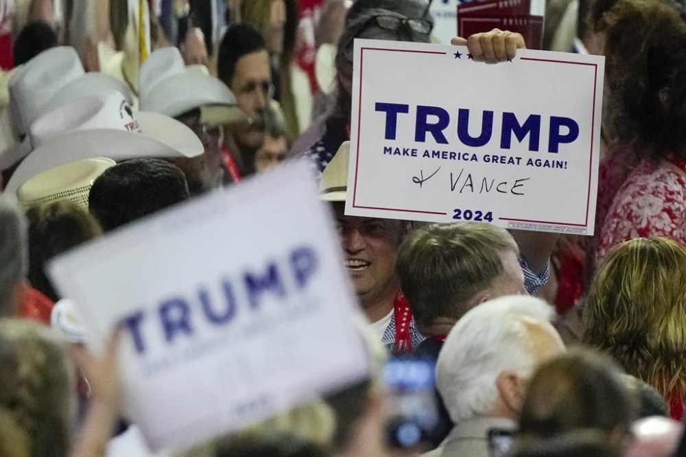 Delegates add Republican vice presidential candidate Sen. JD Vance, R-Ohio, to their signs during the Republican National Convention Monday, July 15, 2024, in Milwaukee. (AP Photo/Matt Rourke)