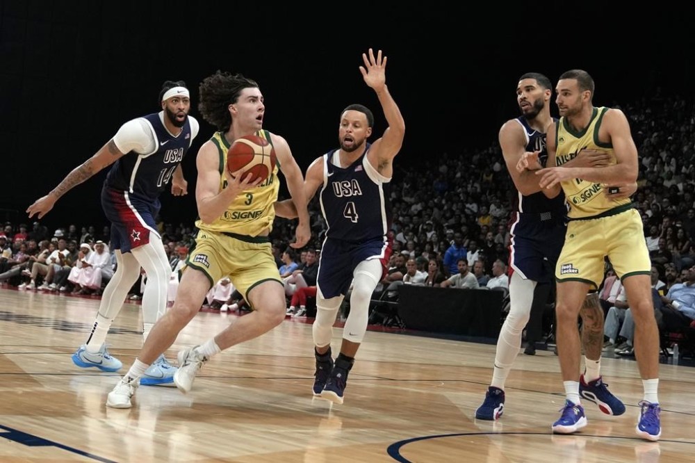 Australia's Josh Giddey (3) drives with the ball past United States' Stephen Curry (4)during the USA Basketball Showcase in Abu Dhabi, United Arab Emirates, Monday, July 15, 2024. (AP Photo/Altaf Qadri)