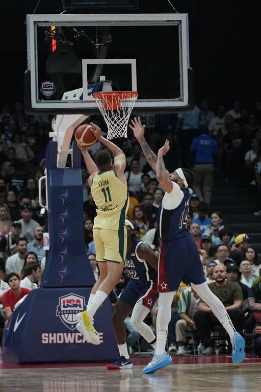 Australia's Dante Exum (14) puts up a shot as USA's Anthony Davis (14) defends during the USA Basketball Showcase in Abu Dhabi, United Arab Emirates, Monday, July 15, 2024. (AP Photo/Altaf Qadri)