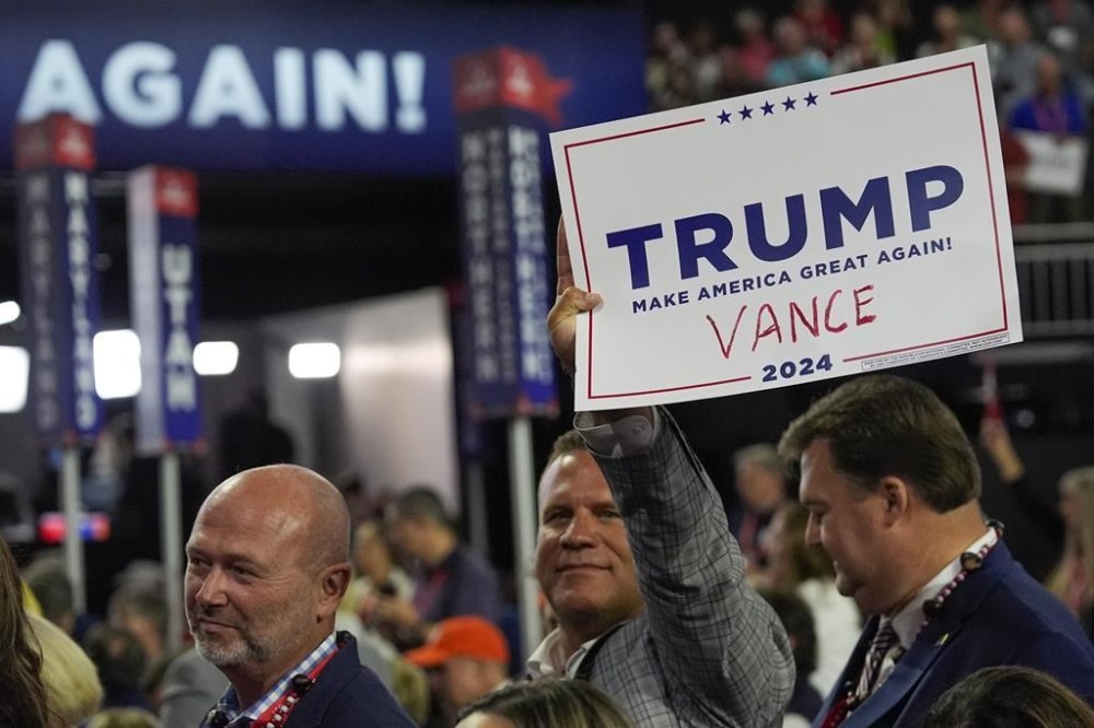 A delegate holds a sign with 'Vance