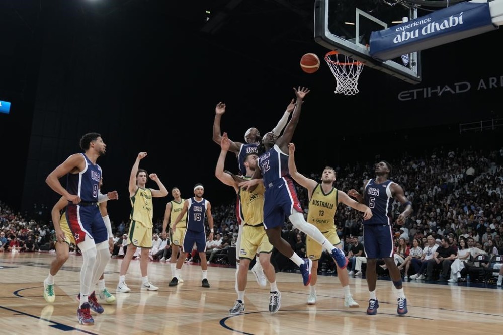 United States and Australia players fight for the ball during the USA Basketball Showcase in Abu Dhabi, United Arab Emirates, Monday, July 15, 2024. (AP Photo/Altaf Qadri)