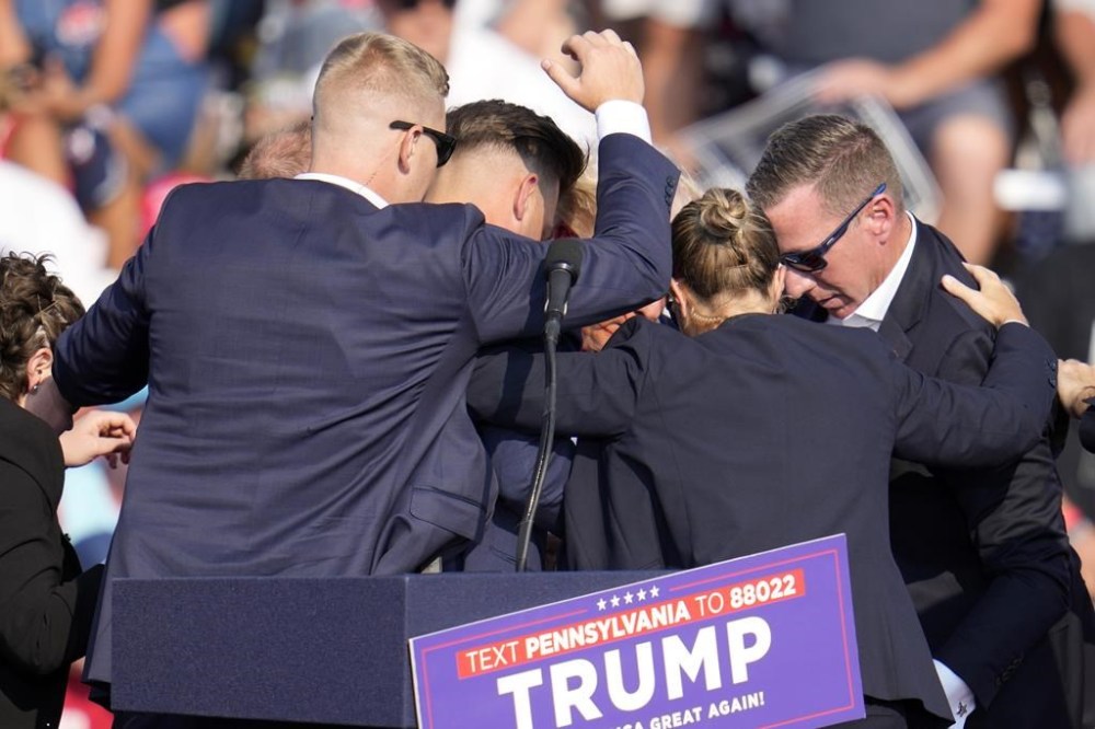 Republican presidential candidate former President Donald Trump is surrounded by U.S. Secret Service at a campaign event in Butler, Pa., on Saturday, July 13, 2024. (AP Photo/Gene J. Puskar)