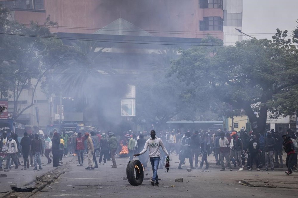 People burn car tyres during a protest in Nairobi, Kenya, Tuesday, July 16, 2024. Police in Kenya hurled tear gas canisters to break up protests on Tuesday in Nairobi and other major cities accusing the president of poor governance and calling for his resignation despite his dismissal of nearly the entire Cabinet last week. (AP Photo/Ed Ram)