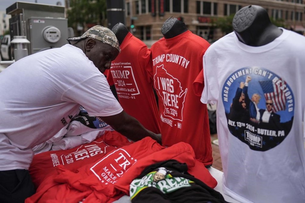 A vendor sorts his merchandise is seen during the second day of the 2024 Republican National Convention near the Fiserv Forum, Tuesday, July 16, 2024, in Milwaukee. (AP Photo/Jae C. Hong)