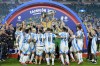 Argentina kitman Mario De Stefano holds up the trophy as he celebrates with players after defeating Colombia in the Copa America final soccer match in Miami Gardens, Fla., Monday, July 15, 2024. (AP Photo/Rebecca Blackwell)