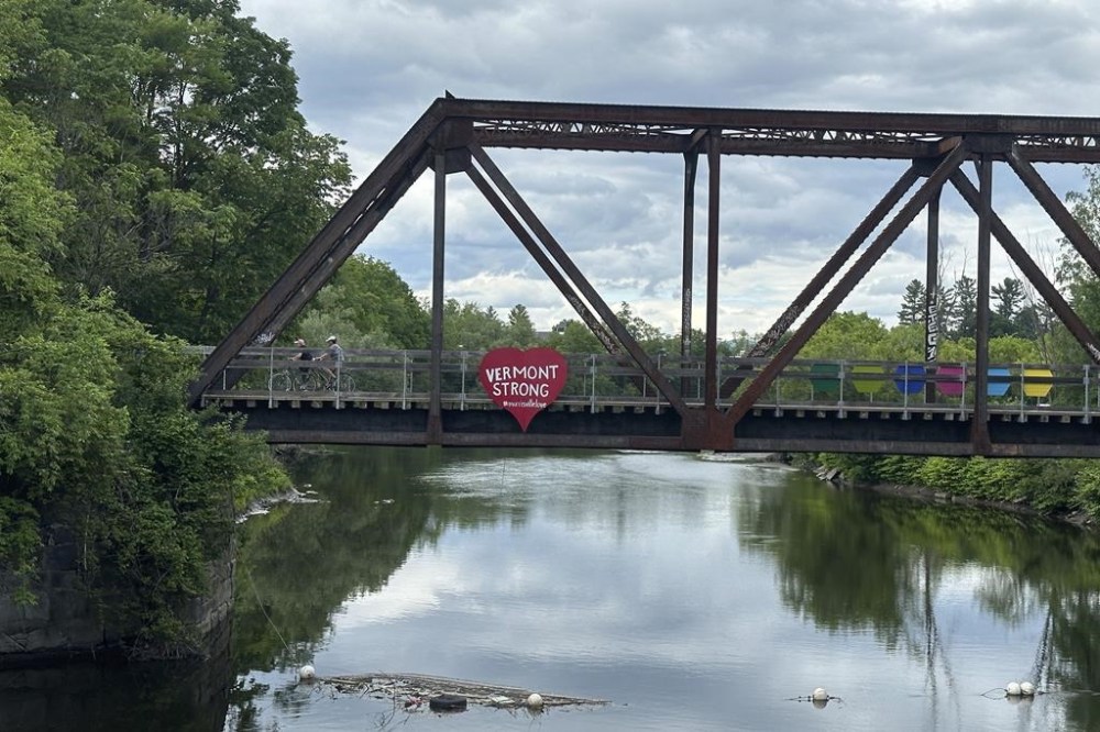 Cyclists ride across a converted railroad bridge over the Lamoille River in Morrisville, Vt., on Wednesday June 12, 2024. (AP Photo/Wilson Ring)