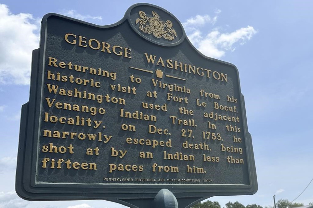 An historical marker near the spot where George Washington “narrowly escaped death” years before he became America’s first president sits alongside a rural road near Butler, Pa, Tuesday, July 16, 2024, near the site of Saturday’s attempted assassination of Republican presidential candidate former President Donald Trump. (AP Photo/Julie Carr Smyth)