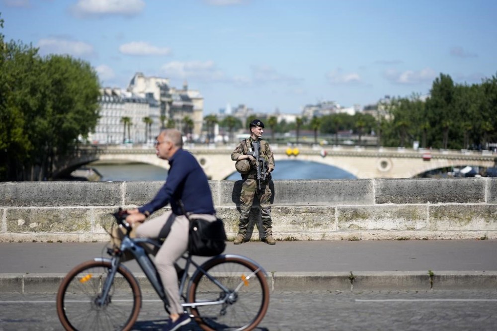 A soldier stands on a bridge over the Seine river, Wednesday, July 17, 2024, in Paris, nine days before the start of the Paris 2024 Olympic Games. (AP Photo/David Goldman)