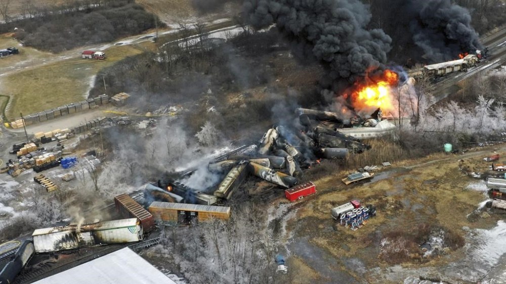 FILE - Debris from a Norfolk Southern freight train lies scattered and burning along the tracks Feb. 4, 2023, the day after it derailed in East Palestine, Ohio. The EPA's Inspector General announced Tuesday, July 16, 2024, an investigation into why the agency didn't get its specialized plane loaded with advanced sensors into the air over East Palestine until four days after the derailment last year. (AP Photo/Gene J. Puskar, File)