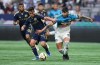 Vancouver Whitecaps' Andres Cubas, left, and Sporting Kansas City's Alan Pulido vie for the ball during the first half of an MLS soccer match, in Vancouver, on Wednesday, July 17, 2024. THE CANADIAN PRESS/Darryl Dyck