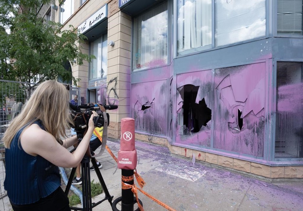 A journalist films vandalism at the constituency office of federal Immigration Minister Marc Miller Thursday, July 18, 2024, in Montreal. THE CANADIAN PRESS/Ryan Remiorz