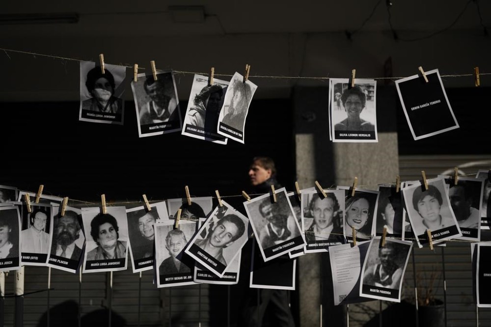 Pictures of bombing victims hang for a ceremony marking the 30th anniversary of the bombing of the AMIA Jewish center that killed 85 people in Buenos Aires, Argentina, Thursday, July 18, 2024. (AP Photo/Natacha Pisarenko)