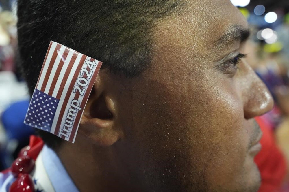 A delegate wears an American flag over his right ear, instead of a bandage, during the Republican National Convention Thursday, July 18, 2024, in Milwaukee. (AP Photo/Nam Y. Huh)