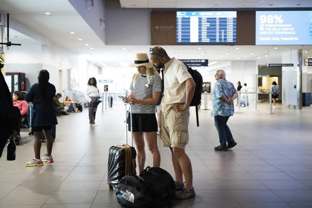 People are seen at Billy Bishop Airport in Toronto on Friday, July 19, 2024. Porter Airlines suspended flights until at least noon as a global tech outage affected flights at the airline. THE CANADIAN PRESS/Christopher Katsarov