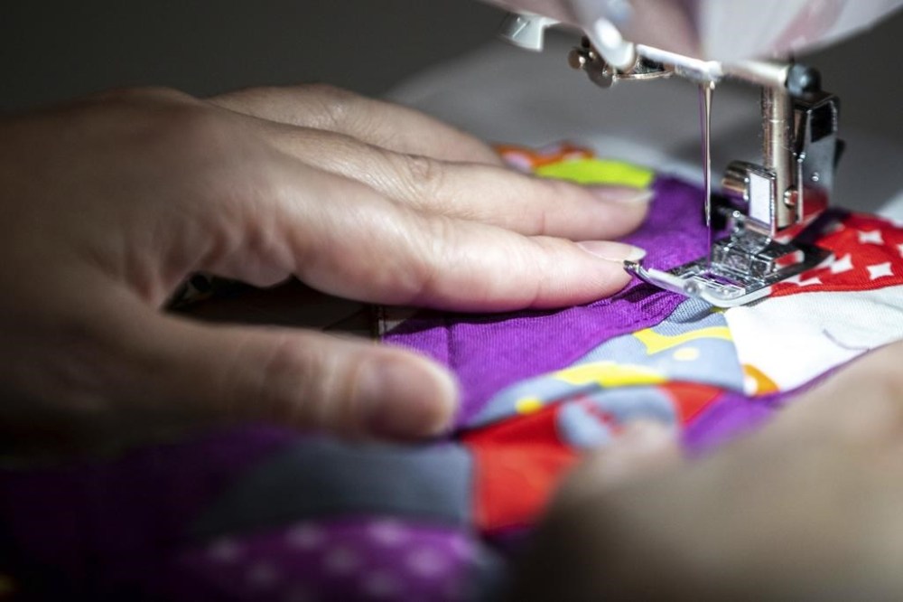 A woman sews at her home in Lincoln, Neb., on March 3, 2022. THE CANADIAN PRESS/AP - Omaha World-Herald, Lily Smith