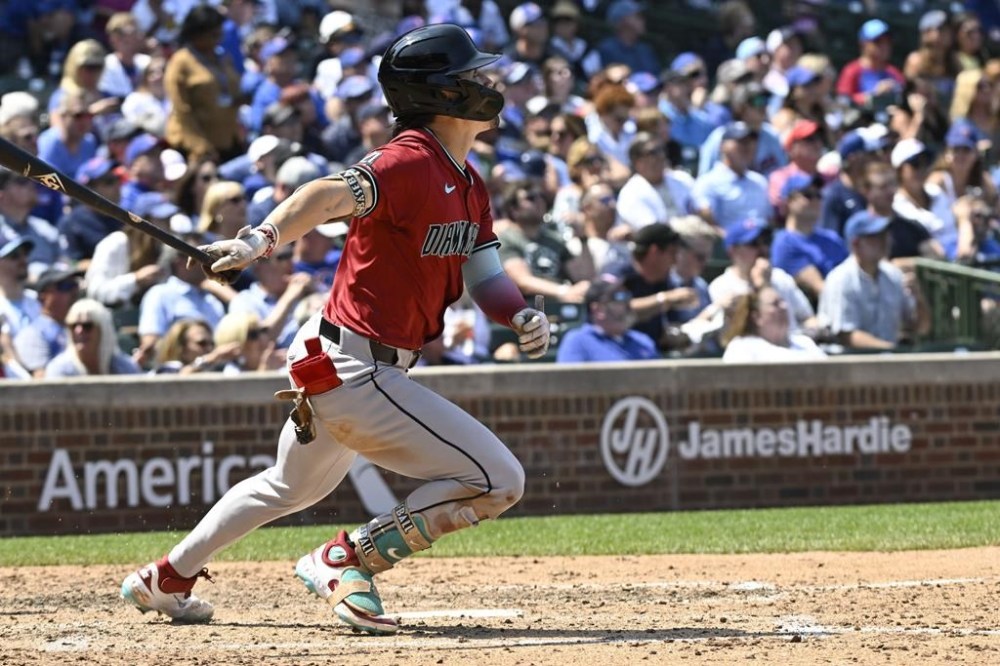 Arizona Diamondbacks' Corbin Carroll drives in a run with a sacrifice fly in the fifth inning of a baseball game against the Chicago Cubs, Friday, July 19, 2024, in Chicago. (AP Photo/Matt Marton)