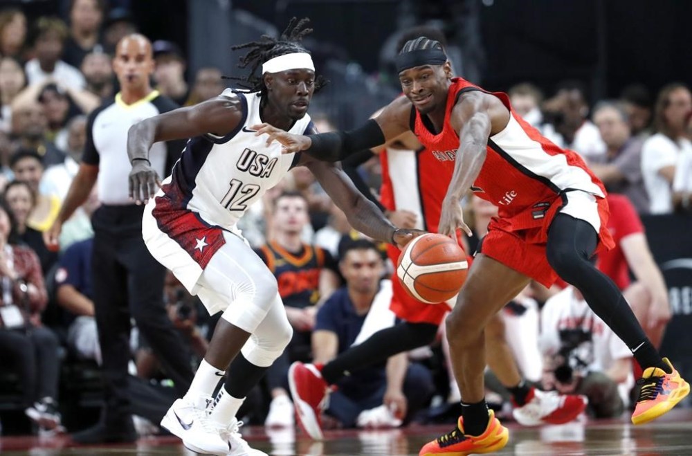 United States guard Jrue Holiday (12) and Canada guard Shai Gilgeous-Alexander (2) vie for the ball during the first half of an exhibition basketball game Wednesday, July 10, 2024, in Las Vegas. THE CANADIAN PRESS/AP-Steve Marcus