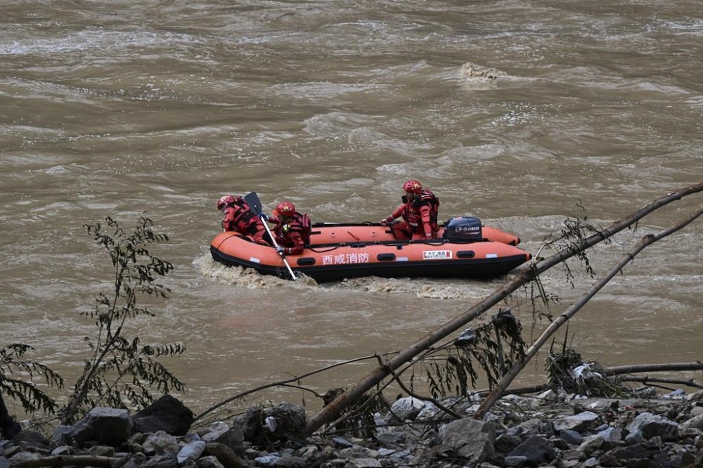 In this photo released by Xinhua News Agency, rescuers on a boat search for survivors on a river following a bridge collapsed in Zhashui County in Shangluo City, northwest China's Shaanxi Province, Saturday, July 20, 2024. Chinese authorities say several people have died and more than dozen are missing in the partial collapse of a highway bridge in the northwest of the country following heavy storms and flooding. A similar number are missing in the southwest after dozens of houses were destroyed by storms. (Zhang Ling/Xinhua via AP)
