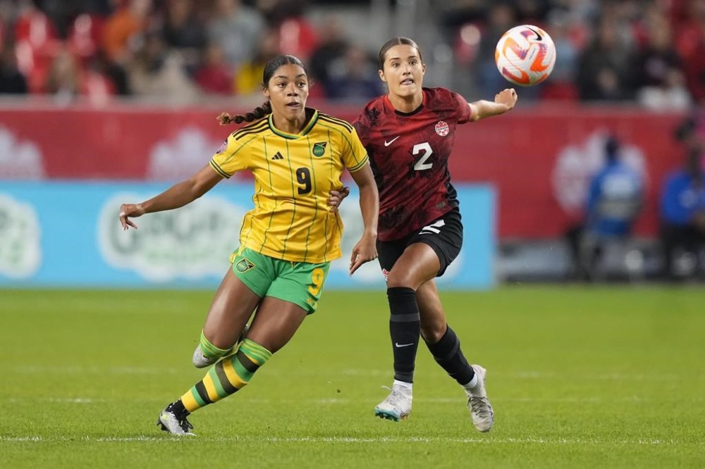 Canada's Sydney Collins, 2, battles Jamaica's Kameron Simmonds for the ball during first half CONCACAF women's championship soccer series match in Toronto on Tuesday Sept. 26, 2023. Defender Collins will not compete for the Canadian women's soccer team at the Paris Olympics after fracturing her left leg during a closed-door match against Nigeria on Wednesday. THE CANADIAN PRESS/Nathan Denette