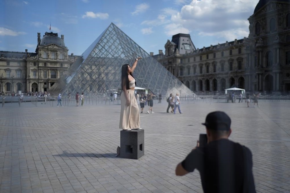 A woman from Mexico poses in the courtyard of the Louvre museum, which is outside the security perimeter set up for the Olympic Games, Friday, July 19, 2024, in Paris, France. (AP Photo/David Goldman)