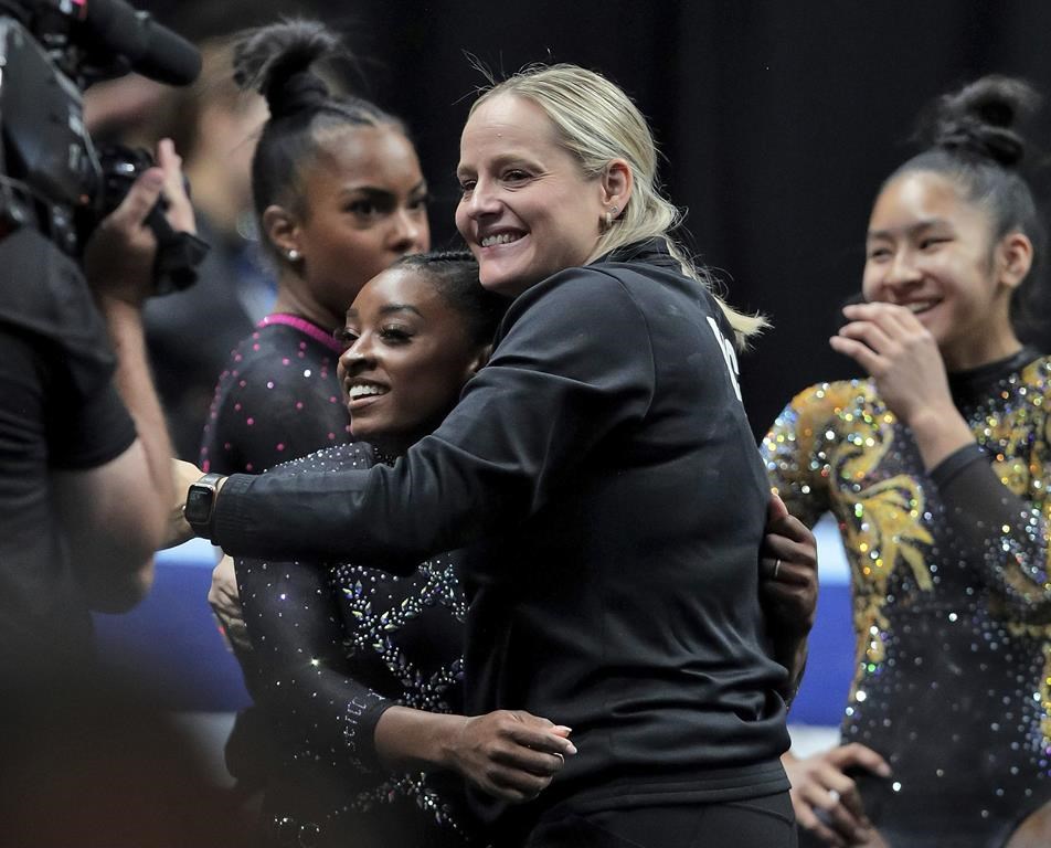 FILE - Simone Biles gets a hug from her coach Cecile Landi after competing in the floor exercise in the U.S. Gymnastics Championships, Sunday, Aug. 27, 2023, in San Jose, Calif. The Landis are have a homecoming of sorts at the Paris Olympics when the French natives help lead Biles and a U.S. women's gymnastics team heavily favored to win gold. (Carlos Avila Gonzalez/San Francisco Chronicle via AP, File)