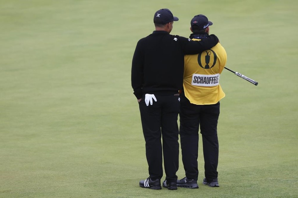 Xander Schauffele of the United States embraces his caddy Austin Kaiser on the 18th green during his final round of the British Open Golf Championships at Royal Troon golf club in Troon, Scotland, Sunday, July 21, 2024. (AP Photo/Scott Heppell)