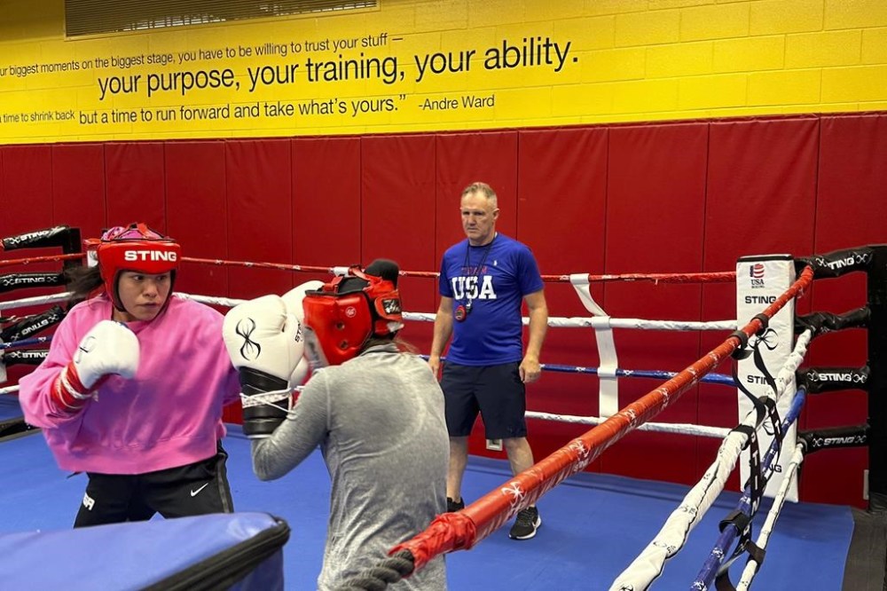 U.S. Olympic boxer Jajaira Gonzalez, left, spars with teammate Jennifer Lozano while head coach Billy Walsh looks on at the U.S. Olympic Training Center in Colorado Springs, Colo., June 14, 2024. Eight years after Gonzalez narrowly missed out on qualification for the Rio de Janeiro Games, she revived her boxing career and earned an Olympic berth in Paris. (AP Photo/Greg Beacham)