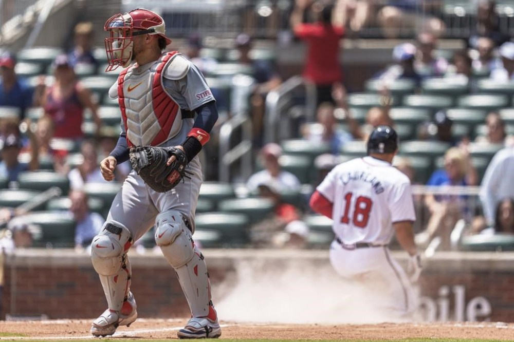 St. Louis Cardinals catcher Willson Contreras, left, waits for the ball as Atlanta Braves' Ramon Laureano (18) slides into home plate in the sixth inning of a baseball game, Sunday, July 21, 2024, in Atlanta. (AP Photo/Jason Allen)