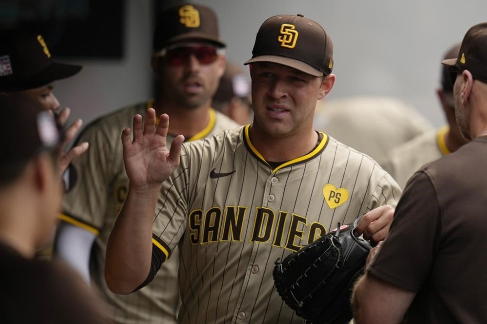 San Diego Padres pitcher Michael King is greeted in the dugout after the seventh inning of a baseball game against the Cleveland Guardians, Sunday, July 21, 2024, in Cleveland. (AP Photo/Sue Ogrocki)