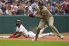 Cleveland Guardians' Angel Martínez, left, slides safely into third base as San Diego Padres third baseman Manny Machado, right, throws to second base for an out against Guardians' José Ramírez in the seventh inning of a baseball game Sunday, July 21, 2024, in Cleveland. (AP Photo/Sue Ogrocki)