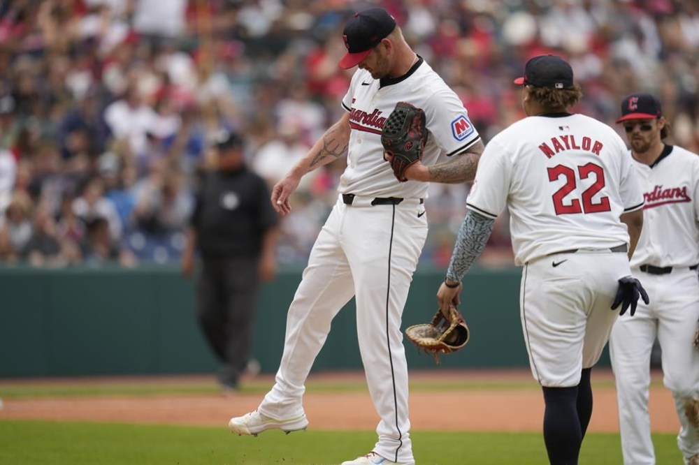 Cleveland Guardians pitcher Ben Lively, left, kicks the dirt as he is taken out in the sixth inning of a baseball game against the San Diego Padres, Sunday, July 21, 2024, in Cleveland. (AP Photo/Sue Ogrocki)