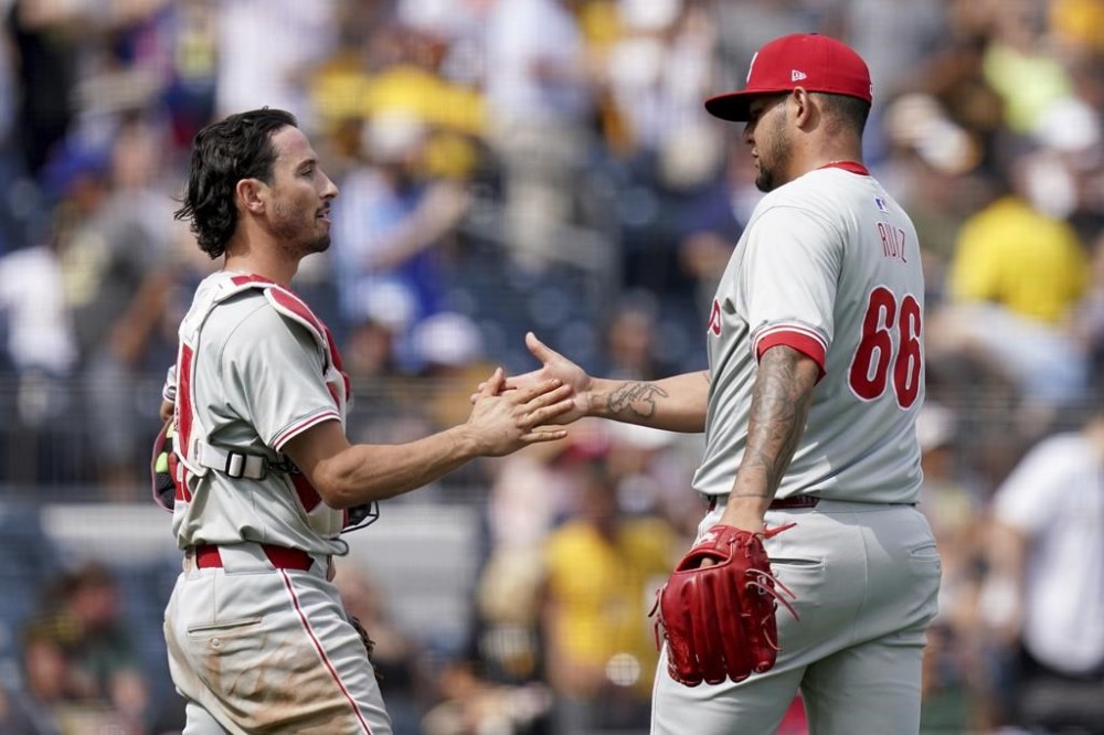 Philadelphia Phillies relief pitcher Jose Ruiz, right, celebrates with catcher Garrett Stubbs, left, after getting the final out of a baseball game against the Pittsburgh Pirates, Sunday, July 21, 2024, in Pittsburgh. (AP Photo/Matt Freed)