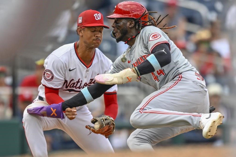 Washington Nationals third baseman Trey Lipscomb, left, tags out Cincinnati Reds' Elly De La Cruz, right, during the sixth inning of a baseball game, Sunday, July 21, 2024, in Washington. (AP Photo/John McDonnell)
